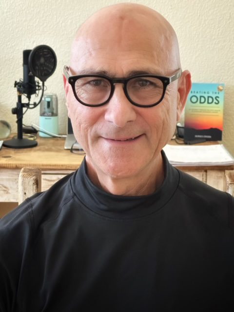 Smiling man with glasses in a cozy room.
