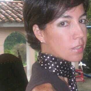 Woman with short hair wearing a polka dot scarf.