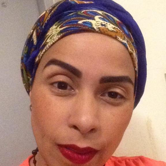 Portrait of a woman with a colorful headscarf and red lipstick.